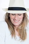 Woman in white hat and shirt smiles for her headshots in Niagara